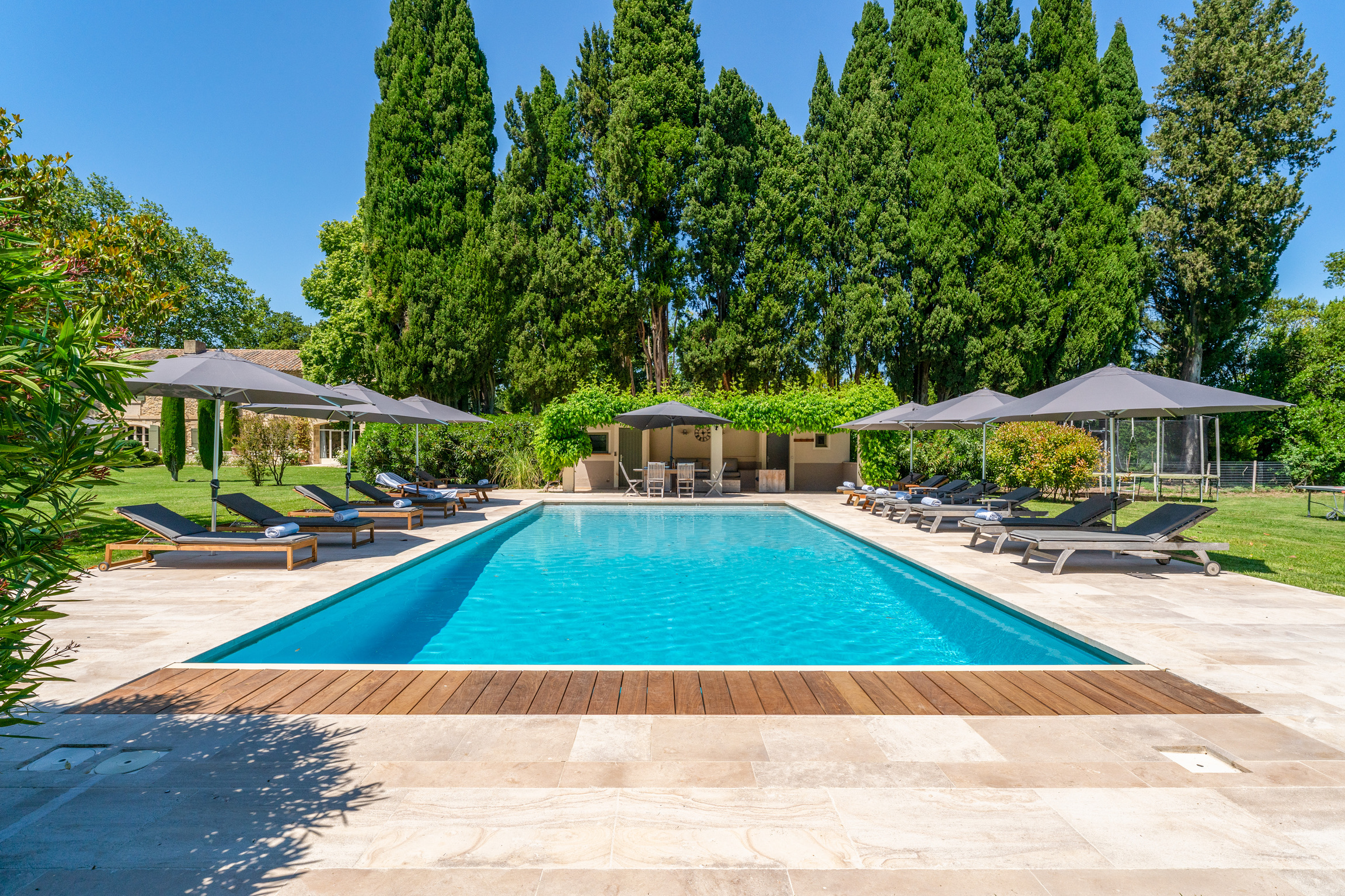 Swimming pool with lounge chairs and cypress trees